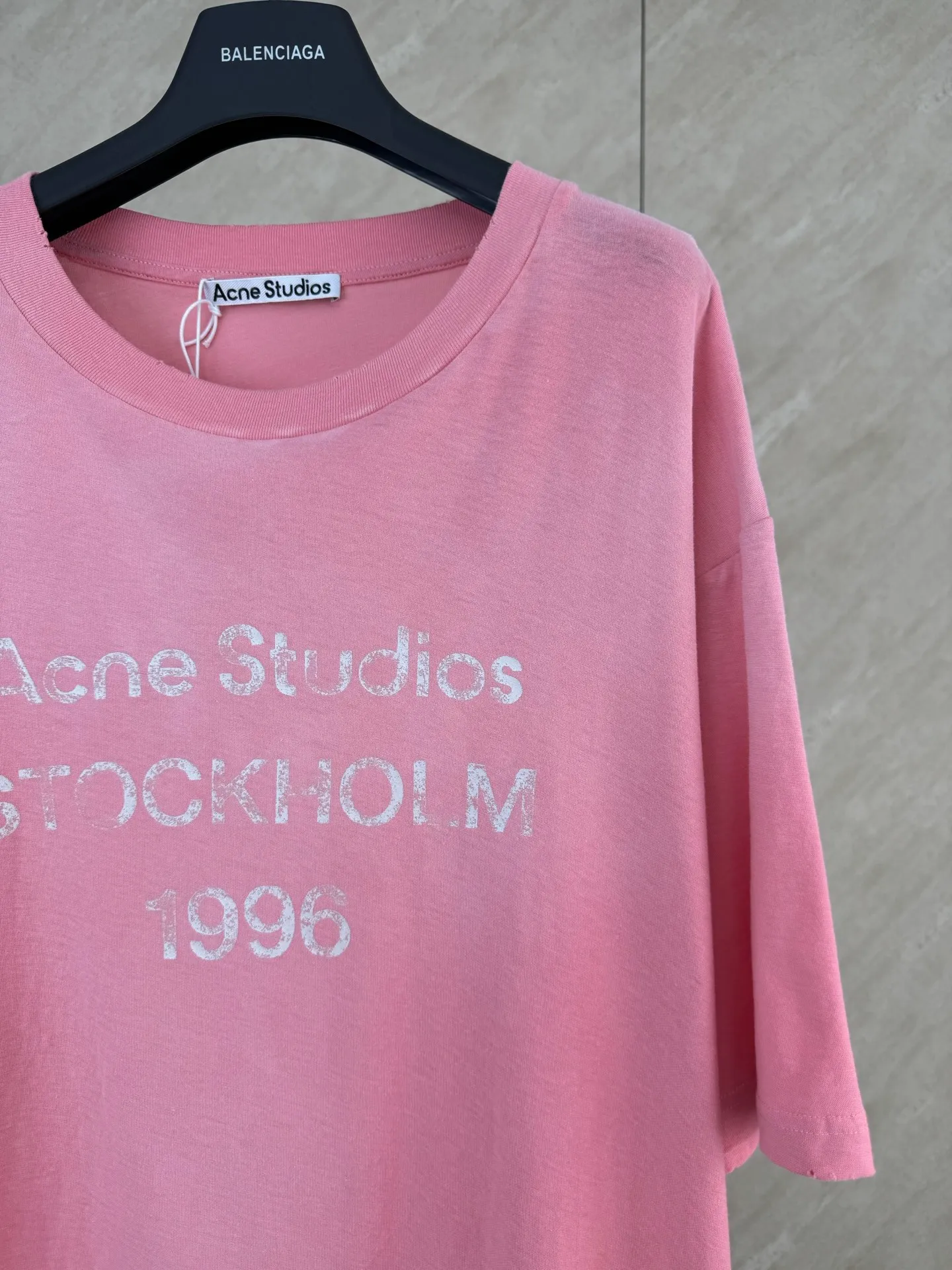 Acne Studio distressed pink fuzzy letter print short-sleeved T-shirt Size: S/M/L/XL Made of 145g/㎡ 85 cotton 15 linen blended jersey jersey. The fabric has been treated with enzyme stone washing and pre-shrinking shaping processes. It combines the softness of cotton and the natural Breathable texture of linen. The fabric surface presents a natural and subtle bamboo texture. The style is a slightly loose straight short long-sleeved cut. The neckline is made of a ribbed crew neck made of this material. The edges of the collar are frayed by hand with distressed raw edges. The inner collar is made of ring-stitched collar technology to resist stretching and sagging for a long time. The front of the body is printed with Retro crack glue printing technology and the ink is treated with aging cracks to restore the worn texture of the vintage. The shoulder seams and side seams are reinforced with four-thread overlock seams, and the cuffs and hem are closed with narrow hems and double-needle flat turning seams. The cotton and linen blended base has a matte washed matte color, with a distressed collar and Retro cracked printing. It combines natural linen and cotton blended fabrics, enzyme washing technology and a relaxed short long-sleeved silhouette, taking into account the suitability for both single wear and inner wear, and fully presents the fine washing and printing process details of Nordic Retro ready-to-wear.